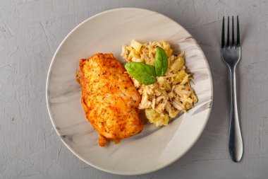 Fırında tavuk göğsü ve gri arka plandaki çatalın yanında salata. Yatay fotoğraf