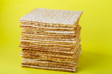 Kare matzo birbiri ardına sarı arka planda birkaç çarşaf. Yatay fotoğraf