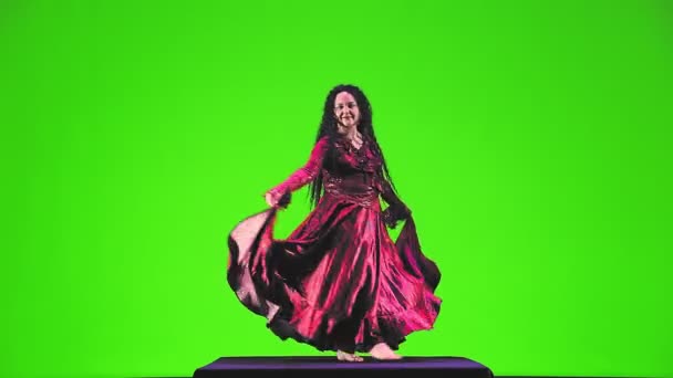 Cyganka Długimi Czarnymi Włosami Czerwonym Garniturze Tańczy Zapalająco Zielonym Tle — Wideo stockowe