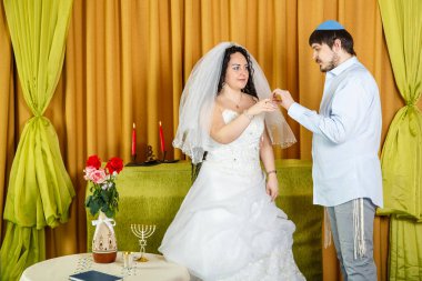 Bir Yahudi sinagog düğününde yapılan chuppah töreninde damat gelinin işaret parmağına yüzük takar. Yatay fotoğraf