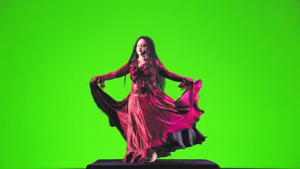 一个赤脚的吉普赛女人穿着红色西服 一头长长的黑头发 在绿色的背景下激烈地跳舞 总体计划 — 图库视频影像