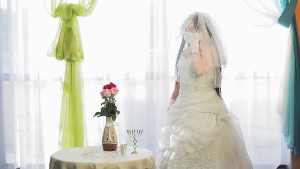 結婚式のドレスを着たユダヤ人の花嫁と チュパの儀式が喜んで電話で話す前に シナゴーグホールで医療マスクを着用したベール 計画全体 — ストック動画