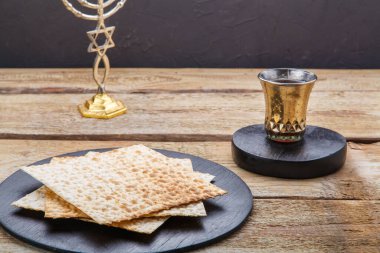 Yuvarlak ahşap bir tahtanın üzerinde bir şamdan ve masanın yanında bir bardak kiraz şarabı var. Yatay fotoğraf