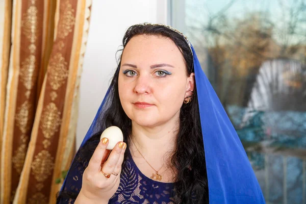 Еврейская Женщина Головой Покрытой Голубым Плащом Пасхальным Столом Съедает Яйцо — стоковое фото