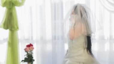 Hupap seremonisi tebrikleri kabul edip telefonda konuşmadan önce gelinlik ve tıbbi maske takan Yahudi bir gelin. Ortam planı