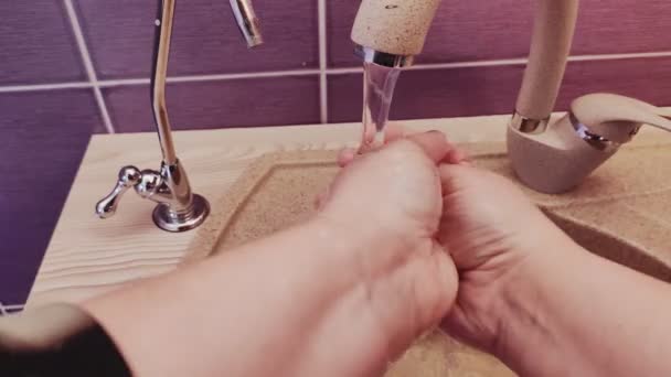 En kvinna tvättar händerna med tvål i handfatet under rinnande vatten i första person. — Stockvideo