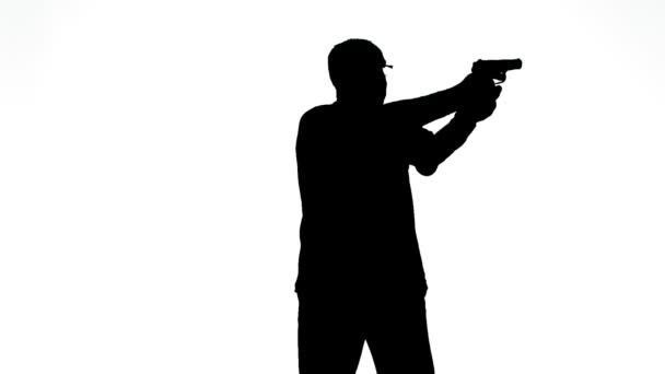 Silhouet van een man in profiel die een pistool afvuurt op een witte achtergrond — Stockvideo