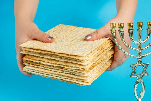 Een Stapel Matzo Vrouwelijke Handen Een Blauwe Achtergrond Bij Menorah — Stockfoto