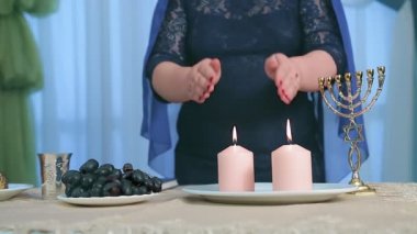 Yüzü olmayan Yahudi bir kadın, Şabat 'ta mum yaktıktan sonra dua okur. Ortam planı