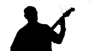 Beyaz arka planda gitar çalan bir adamın silueti. Ortam planı