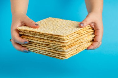 Mavi arkaplandaki matzo yığını kadın ellerinde yatay fotoğraf