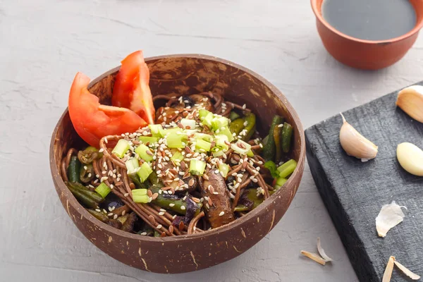 Mantarlı soba ve gri beton arka planda hindistan cevizi kabuğunda susam tohumlu yeşil fasulye. Yatay fotoğraf