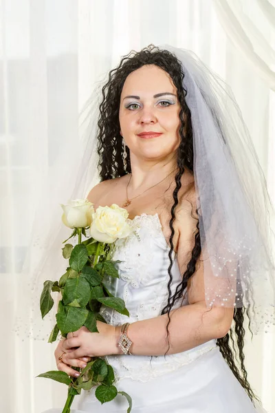 右手に白いバラの花束を持つチュッパ式の前にホールに立つユダヤ人の花嫁、腰への写真. — ストック写真