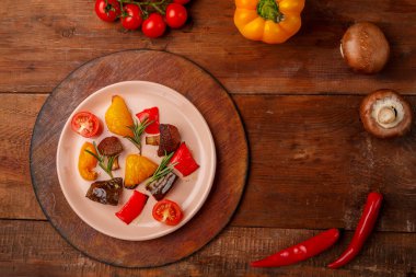 Tabaktaki antimakarna ahşap bir masada taze sebzelerin yanında..