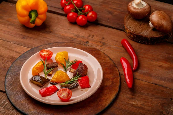 Tahta bir masada, taze sebzelerin yanında duran bir tabakta antimakarna.. — Stok fotoğraf