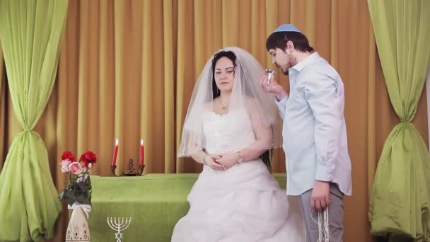 Durante la ceremonia del chuppah, los novios judíos en la sinagoga beben vino. — Vídeo de stock