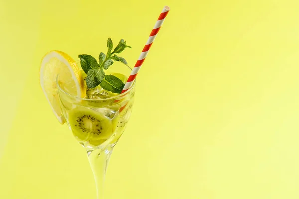 Kiwi-Cocktail mit Zitrone und Minze im Glas auf Serviette auf gelbem Hintergrund. — Stockfoto