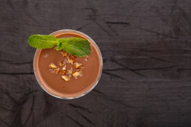 Fındıklı çikolata kokteyli ve siyah arka plan manzaralı bir bardakta nane şekeri. Yatay fotoğraf