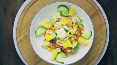 Salata, salatalık ve portakalla dekore edilmiş yengeç etiyle ahşap bir stantta salata daire şeklinde döner..