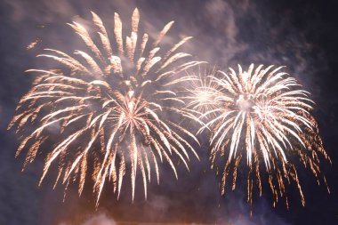 Dumanın içindeki karanlık gökyüzüne karşı parlayan havai fişekler. Yatay fotoğraf