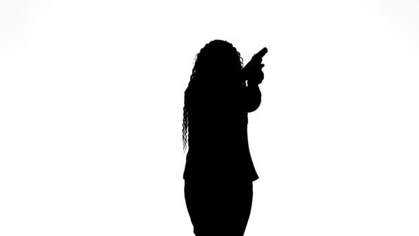 Silhouette d'une femme avec un pistolet pratiquant le tir sur un fond blanc — Video