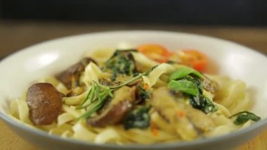 Mantarlı, ıspanaklı ve kiraz domatesli Udon bir tabakta daireler çizer.