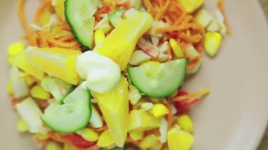 Salatalık ve portakallı yengeç salatası bir tabakta daire şeklinde döner.