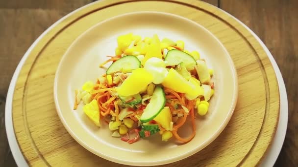 Krabbensalat mit Gurke und Orange in einem Teller auf einem Holzständer dreht sich im Kreis — Stockvideo