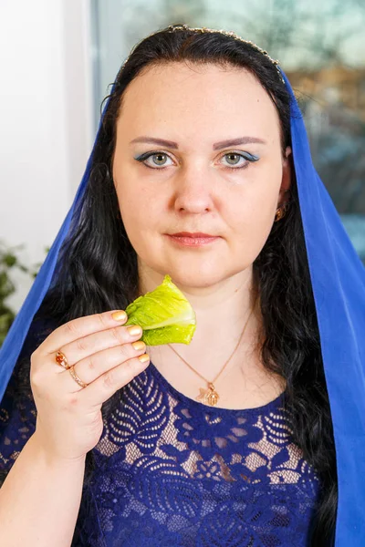 在逾越节的种子桌上 一个头戴蓝色披风的犹太妇女正在吃着灰蒙蒙的雪貂 垂直照片 — 图库照片