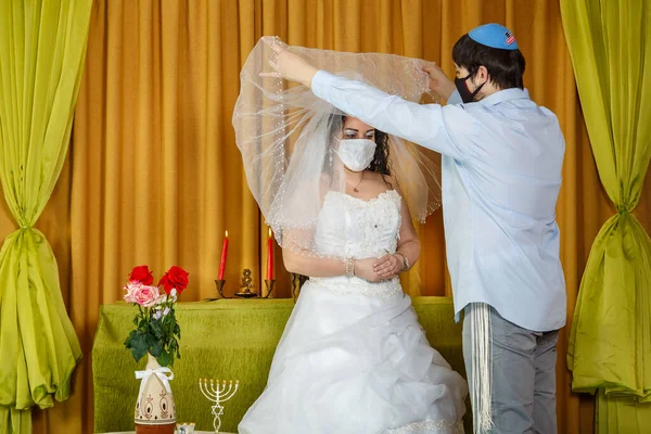 회당에서 있었던 추파 의식중에, 마스크를 쓴 신부와 신랑 이 신부들의 얼굴에서 면사포를 벗기는 모습. — 스톡 사진