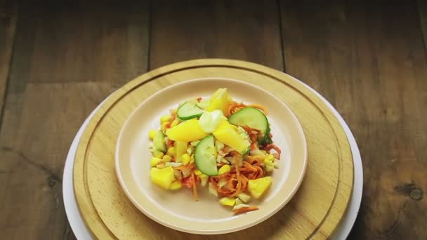 Sallad med krabbkött, garnerad med gurka och apelsin i en tallrik, roterar i en cirkel — Stockvideo