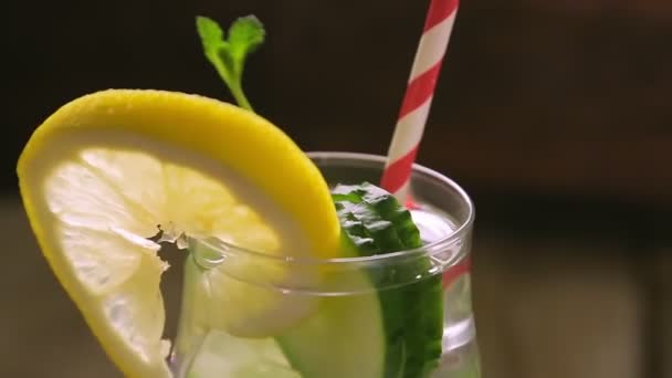 Koktejl s mátovou okurkou a citrónem ve sklenici se otáčí v kruhu — Stock video