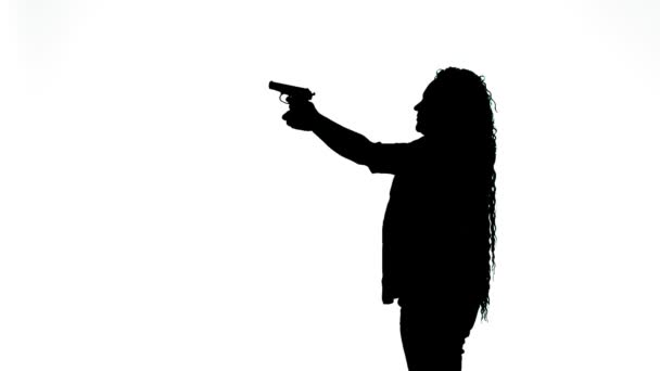 Silhouette di una donna con una pistola che si esercita a sparare su sfondo bianco. — Video Stock