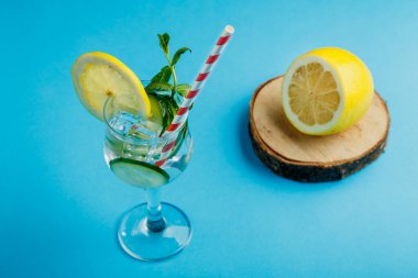 Limonlu salatalık suyu ve limonlu ve nane şekerli kokteyl limonlu ve salatalıklı mavi arka planda bir peçete. Yatay fotoğraf