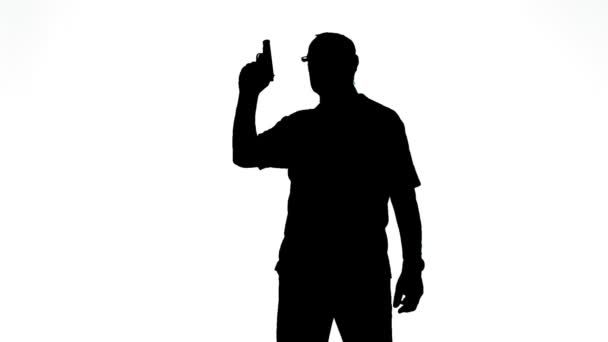 Silueta muže v profilu střílející pistolí na bílém pozadí — Stock video