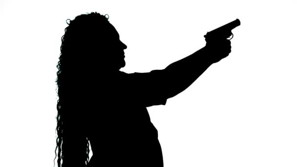 Silhouette d'une femme sur fond blanc tirant un pistolet — Video