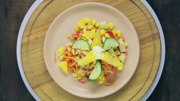Salat mit Krabbenfleisch und Orange in einem Teller auf einem Holzständer dreht sich im Kreis von oben. — Stockvideo