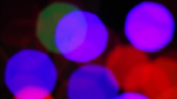 Bokeh desenfoque sobre un fondo negro de rayos multicolores de luz de diodo — Vídeo de stock