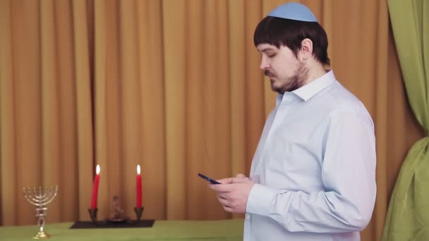 Vor der Chuppah-Zeremonie wählt ein jüdischer Bräutigam im Saal der Synagoge eine SMS per Telefon — Stockvideo