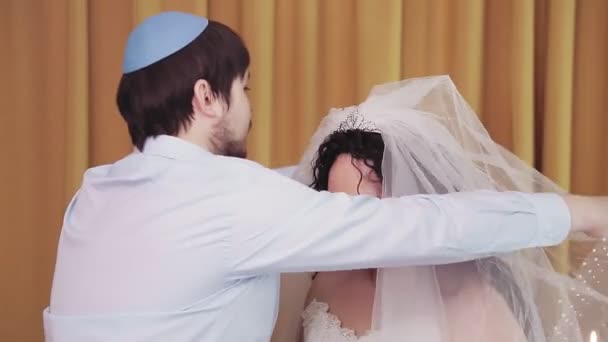 Під час церемонії чуппа, єврейська наречена і наречений в синагозі піднімає вуаль з обличчя наречених. — стокове відео