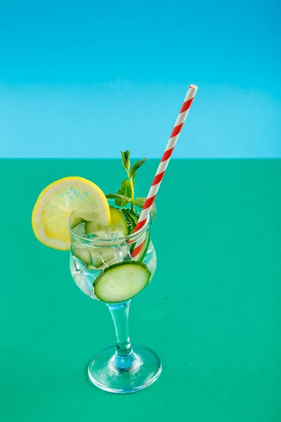 緑の背景にナプキンにガラスのレモンとミントとカクテルキュウリの水. — ストック写真