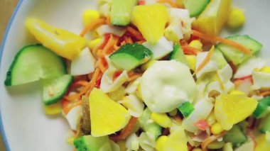 Salatalık ve portakalla süslenmiş yengeç salatası daire şeklinde döner..