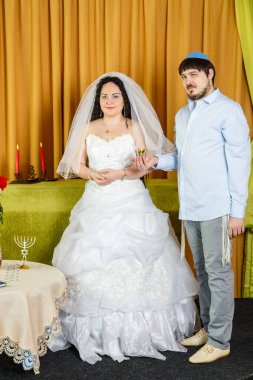 Sinagogdaki chupa seremonisi sırasında damat elinde Kiddush için bir kadeh şarap tutuyor, gelin de yanında duruyor..