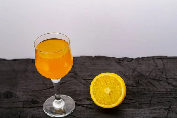 Orange juice in a glass near oranges on a black background. — Stock Photo, Image