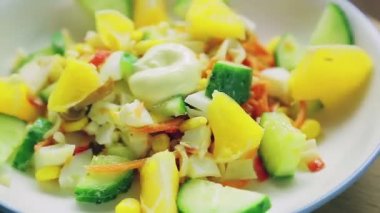 Salatalıkla dekore edilmiş yengeç salatası ve mayonezli turuncu daire şeklinde döner..