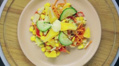 Yengeç etli ve portakallı salata ahşap bir standın üzerinde daire şeklinde döner..