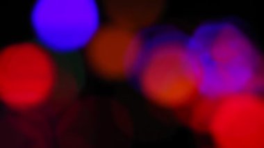 Siyah arkaplanda Bokeh bulanıklığı. Siyah arkaplanda çok renkli ışınlar..