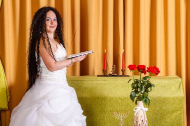 Duvağı olmayan beyaz bir gelinlik içinde Yahudi bir gelin Chupa seremonisinden önce Teo dualarını okur. Yatay fotoğraf