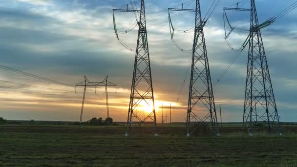 Las torres de transmisión de energía contra el fondo de un crepúsculo cielo al atardecer con nubes corriendo panorama de lapso de tiempo de abajo hacia arriba. — Vídeo de stock