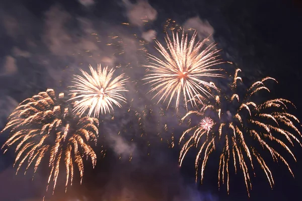 Dumanın içindeki karanlık gökyüzüne karşı parlak, ateşli havai fişekler..